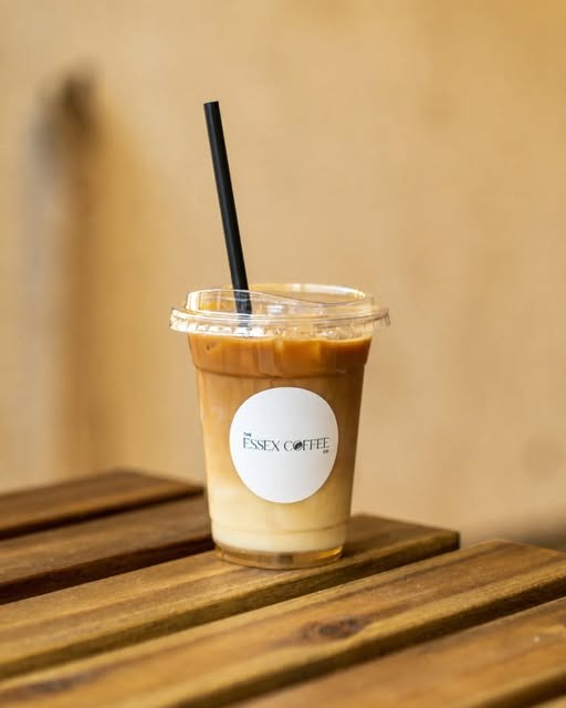 An Essex Coffee Co. iced latte on a wooden table at Basildon Market