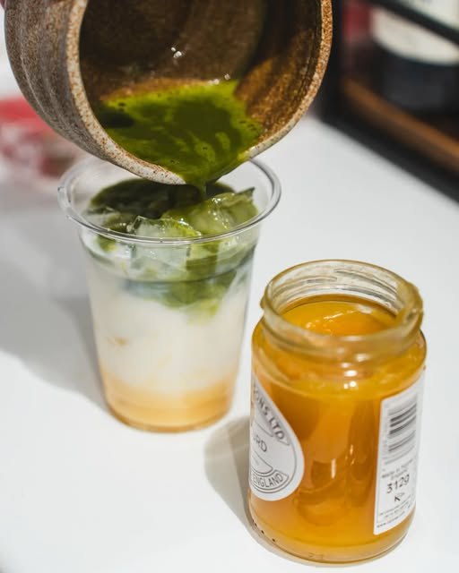 Matcha being poured over ice next to a jar of local honey at Kiosk 10